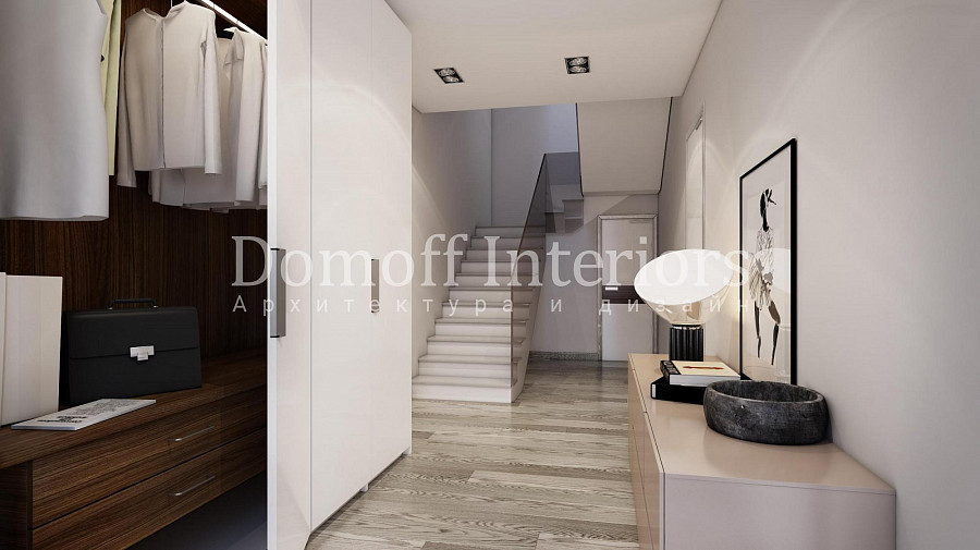 Лестничный коридор первого уровня двухэтажной квартиры выполнен в современном минималистичном стиле с преобладанием белых оттенков